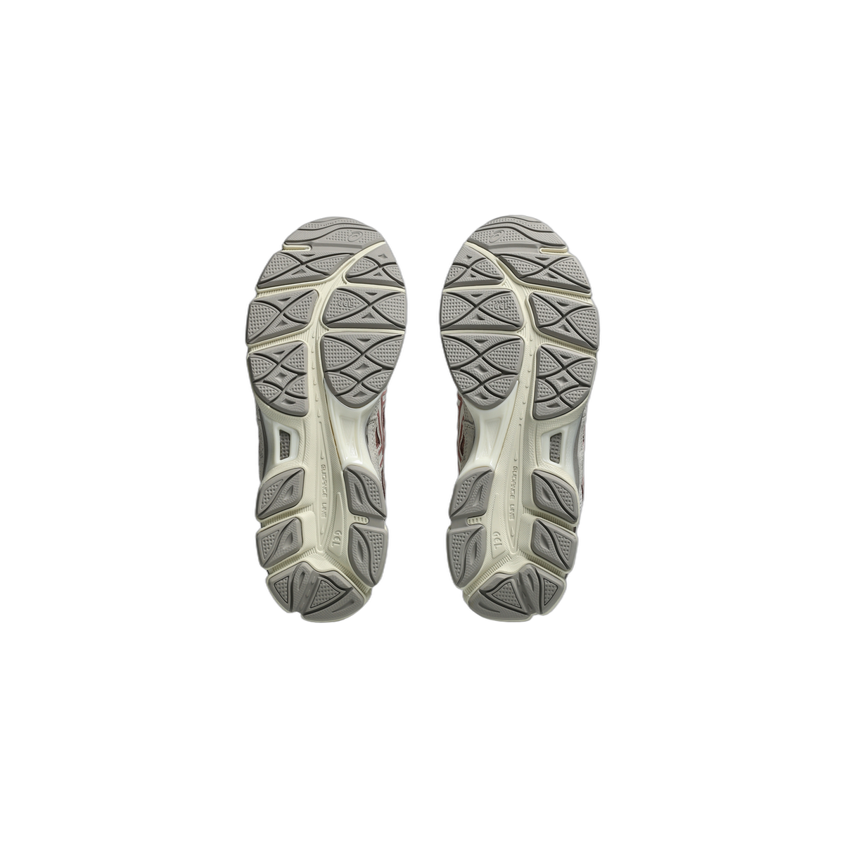 Bottom view of a pair of Asics GEL-NYC sneakers showing the grey and cream tread pattern on both outsoles