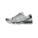 Side view of a white and silver Asics Gel-Kayano 14 sneaker with toe pointing left, featuring metallic silver overlays and a gel cushioning unit in the heel