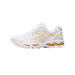 A single white and gold ASICS Gel-Kayano 14 sneaker shown from the outside, toe pointing left, with white mesh panels, gold overlays and gold midsole gel cushioning visible.