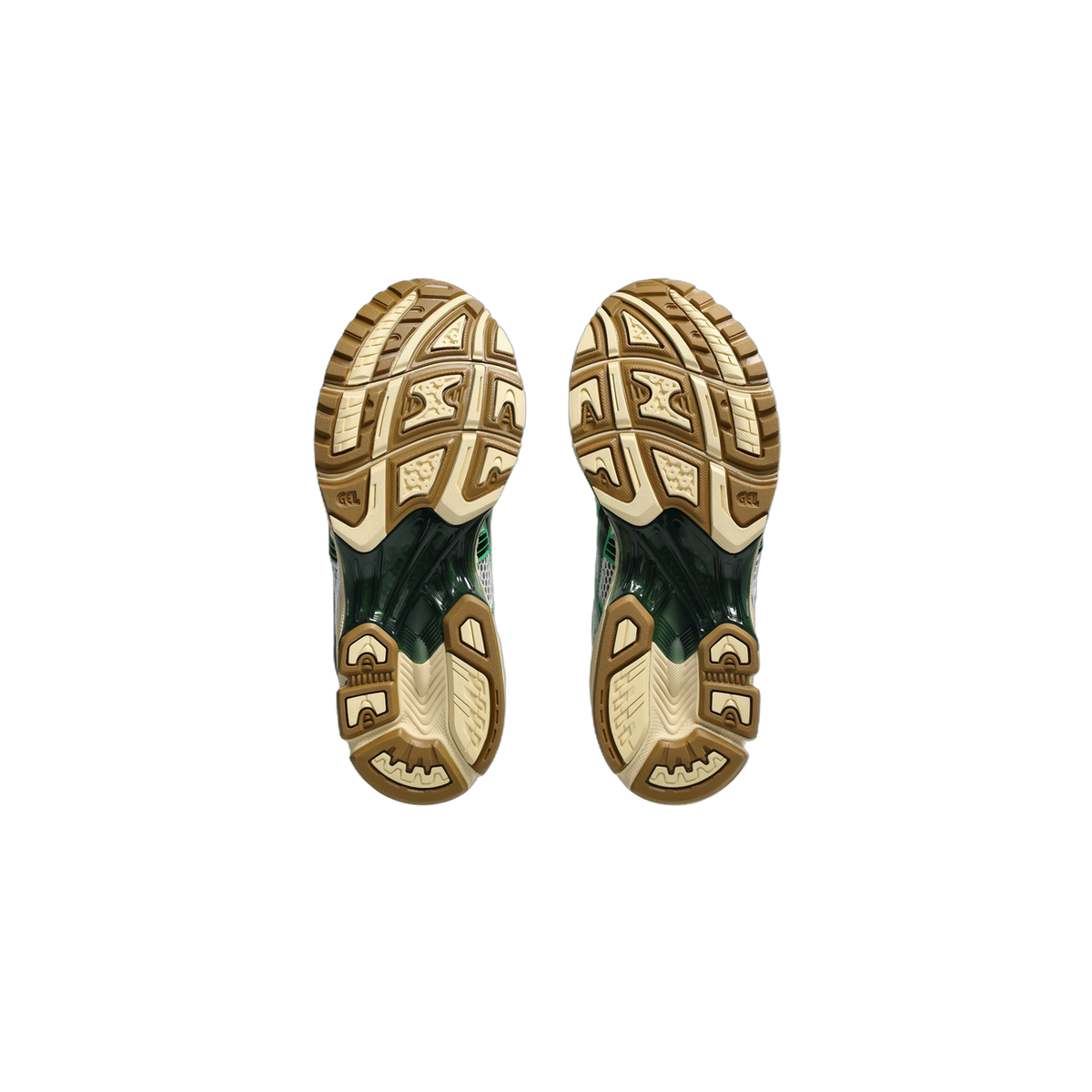 Bottom view of a pair of Asics Gel-Kayano 14 sneakers showing tan and beige tread patterns with dark green midsole accents and GEL branding on the soles.