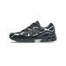 Side view of a black and gray Asics Gel-NYC sneaker with silver overlays, blue accents, and a chunky black outsole, toe pointing left.