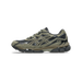 Side view of an Asics Gel-NYC sneaker in olive green suede and black mesh with a visible gel cushioning unit in the brown midsole, toe pointing left.