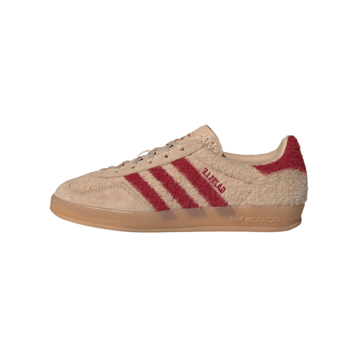 Side view of a beige suede adidas Gazelle Indoor sneaker with red three-stripes and heel patch, gum sole, facing left.