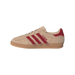 Side view of a beige suede adidas Gazelle Indoor sneaker with red three-stripes and heel patch, gum sole, facing left.