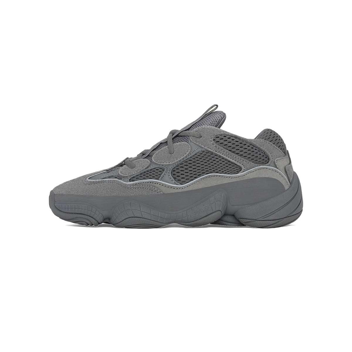 Side view of a gray Adidas Yeezy 500 sneaker with chunky textured sole, mesh upper, and suede overlays, toe pointing left.