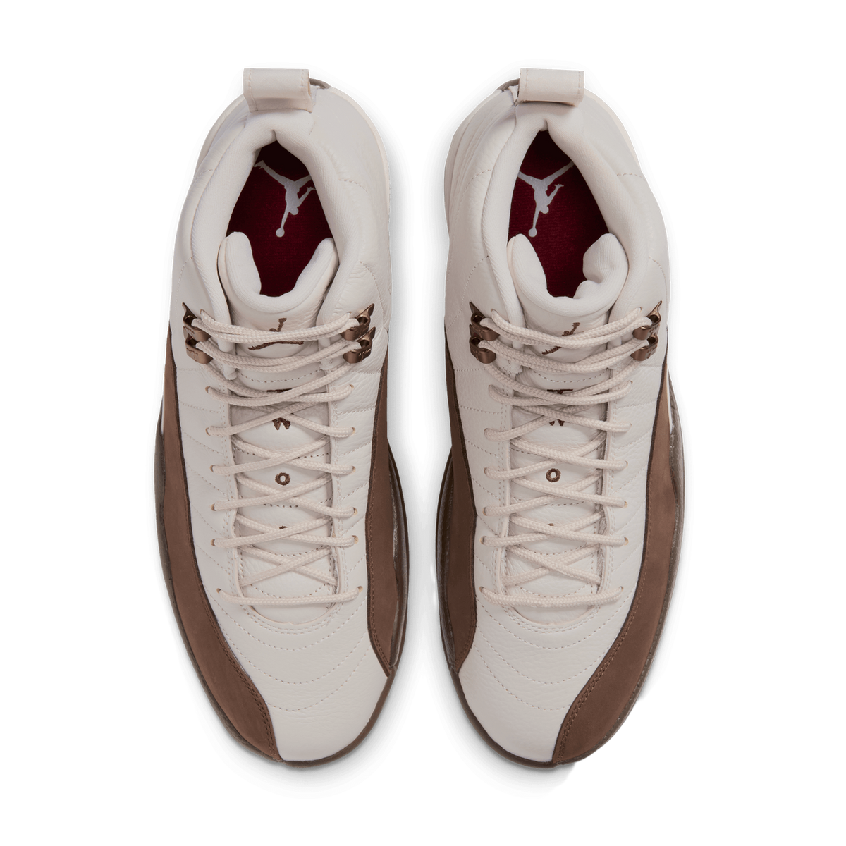 Top-down view of a pair of cream and brown Air Jordan 12 sneakers with dark red interior lining and Jumpman logo on the tongue.