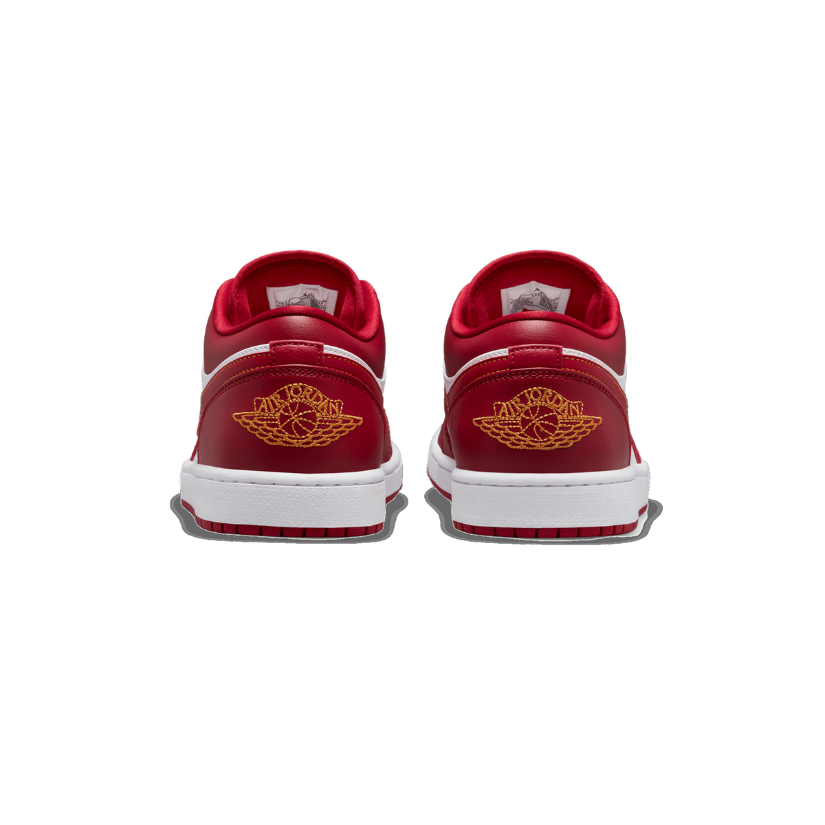 Rear view of a pair of red and white Air Jordan 1 Low sneakers placed side by side, showing the heel tabs with gold embroidered Air Jordan wings logos and the white midsole and outsole.