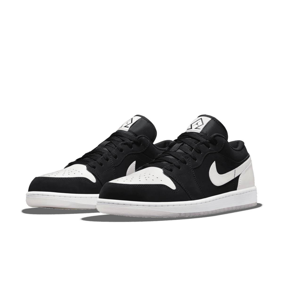Front-angled view of a pair of black and white Jordan 1 Low sneakers with white Swoosh logos and white soles, angled toward the left.