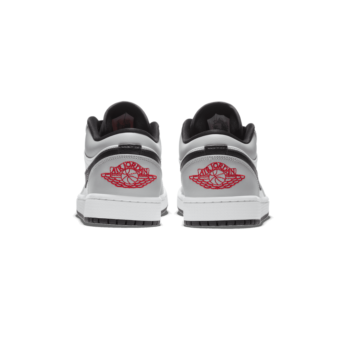 Rear view of a pair of gray, white, and black Air Jordan 1 Low sneakers showing the red embroidered Wings logo on the heels.