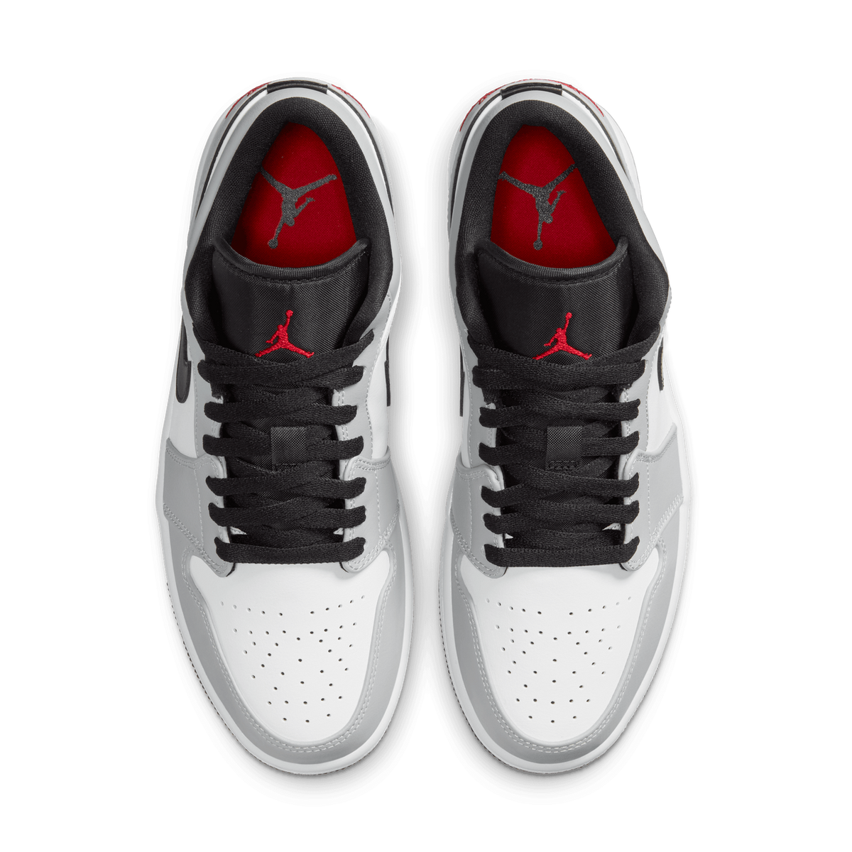 Top-down view of a pair of grey, white, and black Air Jordan 1 Low sneakers with black laces and red Jumpman logos on the red tongue lining