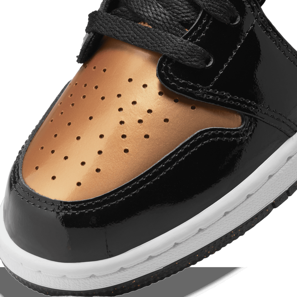 Close-up detail of the toe box of a black and gold patent leather sneaker, showing the glossy gold perforated toe overlay, black stitched panels, black laces, and the white midsole edge.