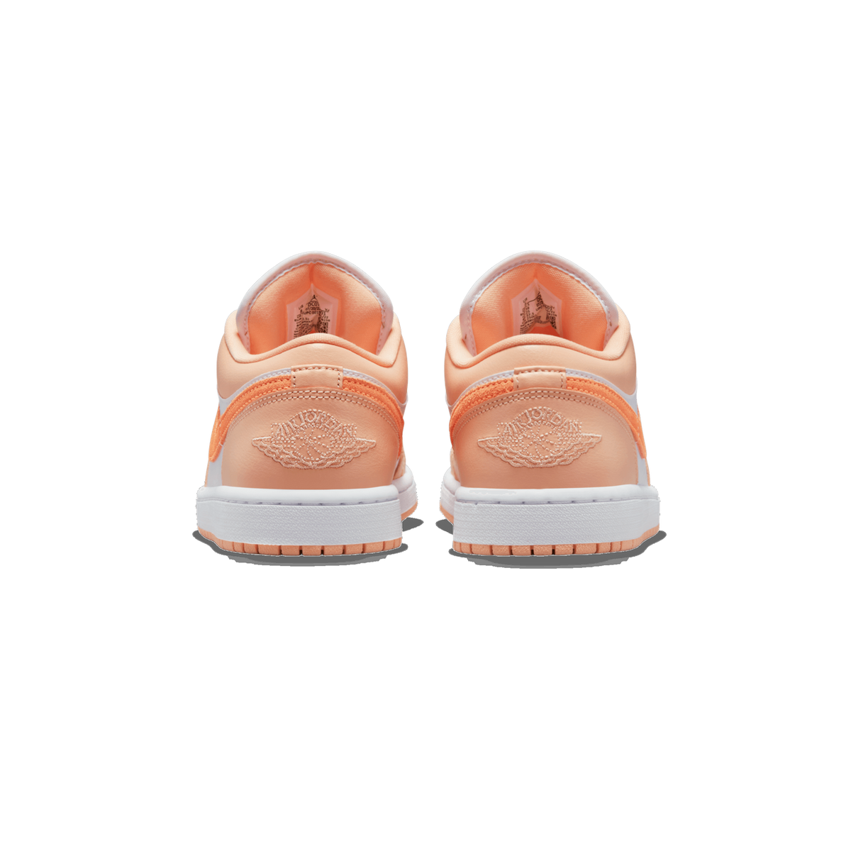 Rear view of a pair of peach-orange and white Air Jordan 1 Low sneakers placed side by side, showing the heel embroidered with the Air Jordan wings logo, orange Swoosh accents, and white midsoles and outsoles.