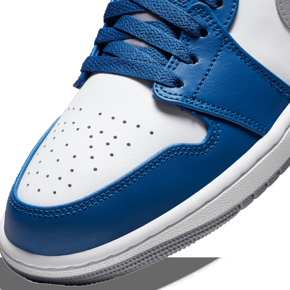 Close-up of the toe box and laces on a blue and white Jordan 1 Low, showing perforated leather, stitching, and the white midsole.