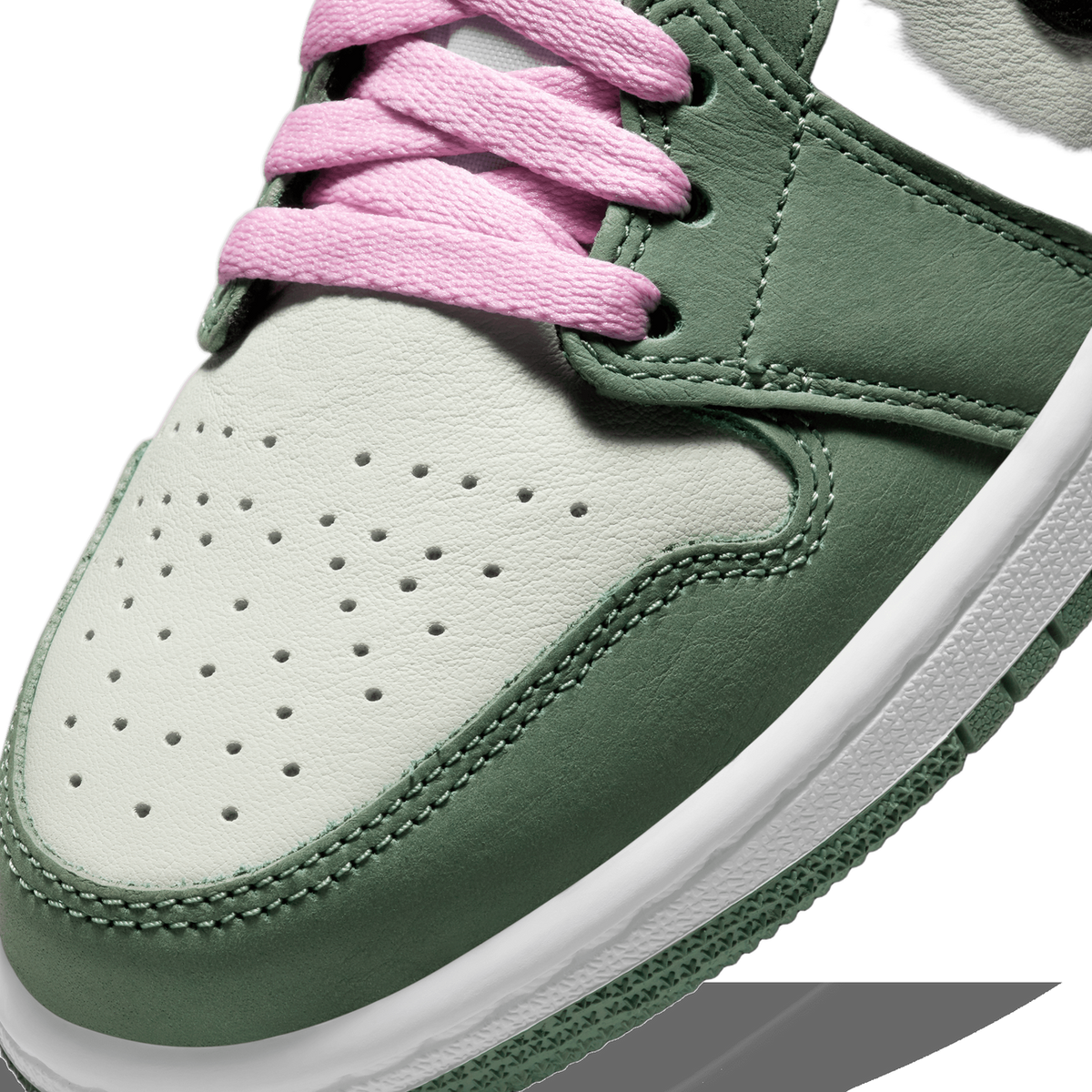 Close-up of the toe box of a green and off-white Jordan 1 Mid sneaker with pink laces and perforated detailing on the toe panel.
