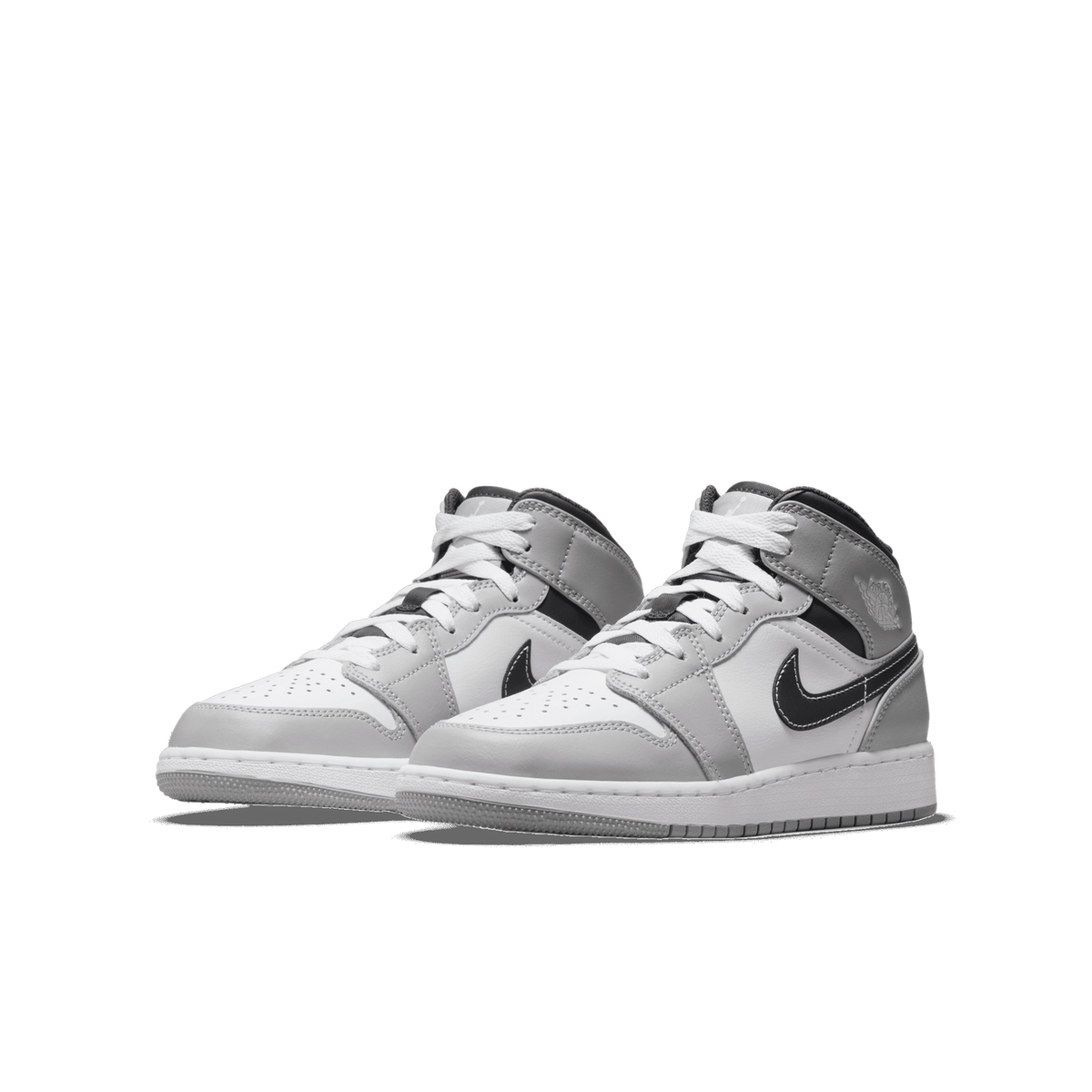 Pair of Jordan 1 Mid sneakers in light smoke grey, white, and black angled toward the left with white laces and black Swoosh logos.
