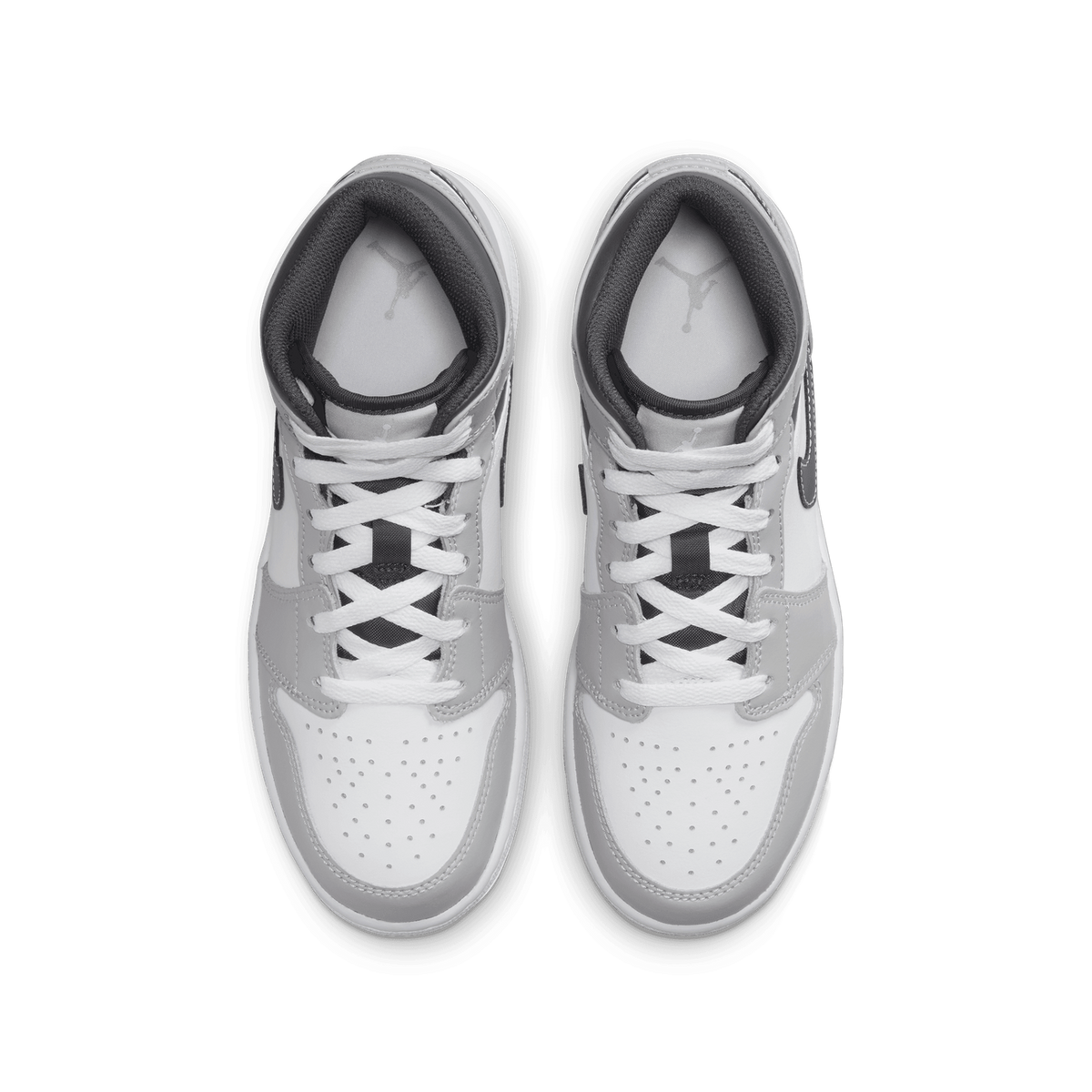 Top-down view of a pair of grey and white Jordan 1 Mid sneakers showing matching laces and padded ankle collars with Jumpman logo branding