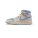 A single high-top sneaker in cream leather with blue fuzzy suede accents on the toe, Swoosh, and collar, shown from the outside with the toe pointing left, displaying the Air Jordan Wings logo on the heel tab and a blue-and-cream outsole.