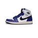 Left Air Jordan 1 Retro High sneaker in white and royal blue leather with black swoosh and Nike Air logo, shown from the side with toe pointing left, cream outsole.