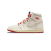 Side profile of a high-top white sneaker with a cream-toned leather upper, red laces, a red Air Jordan wings logo on the ankle, a suede Swoosh, and a red and cream outsole, with the toe pointing left.