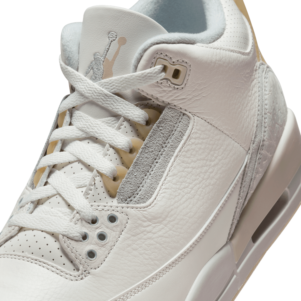 Close-up of the Jordan 3 Retro Craft Ivory's tongue and lacing area, showing the Jumpman logo, white laces, and elephant print detailing on the heel.