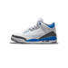 Lateral view of a white Air Jordan 3 Retro sneaker with blue heel and lace accents and black elephant-print detailing on the toe and heel, toe pointing left