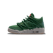 Side profile of a green high-top sneaker with a grey, textured chunky sole, layered green laces wrapped around the upper, gold eyelets, and a red accent at the heel collar, shown with the toe pointing left.