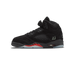 Side view of a black suede Air Jordan 5 high-top sneaker with a red shark-tooth midsole design, glow-in-the-dark '23' branding, and a translucent outsole, toe pointing left.