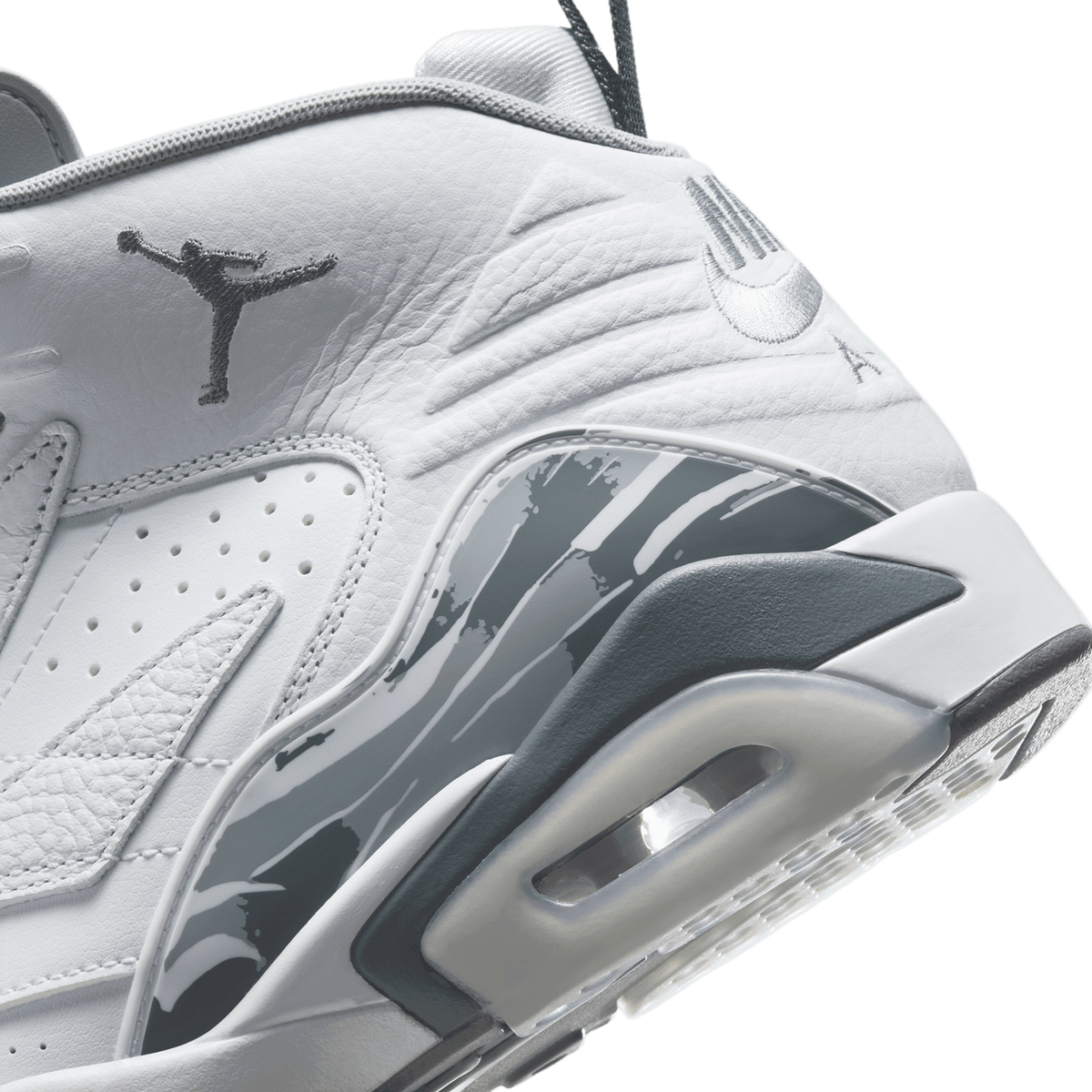 Extreme close-up of a white Jordan MVP sneaker showing the Jumpman logo on the tongue, perforated toe box, and cool grey camo-patterned heel panel.