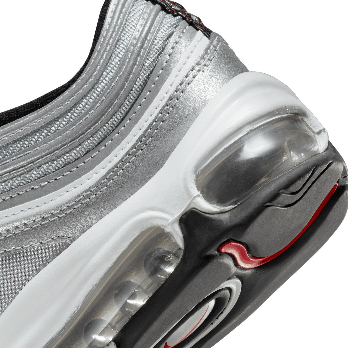 Close-up view of a silver Nike Air Max heel showing the visible air bubble unit, white midsole, and red accent swoosh detail