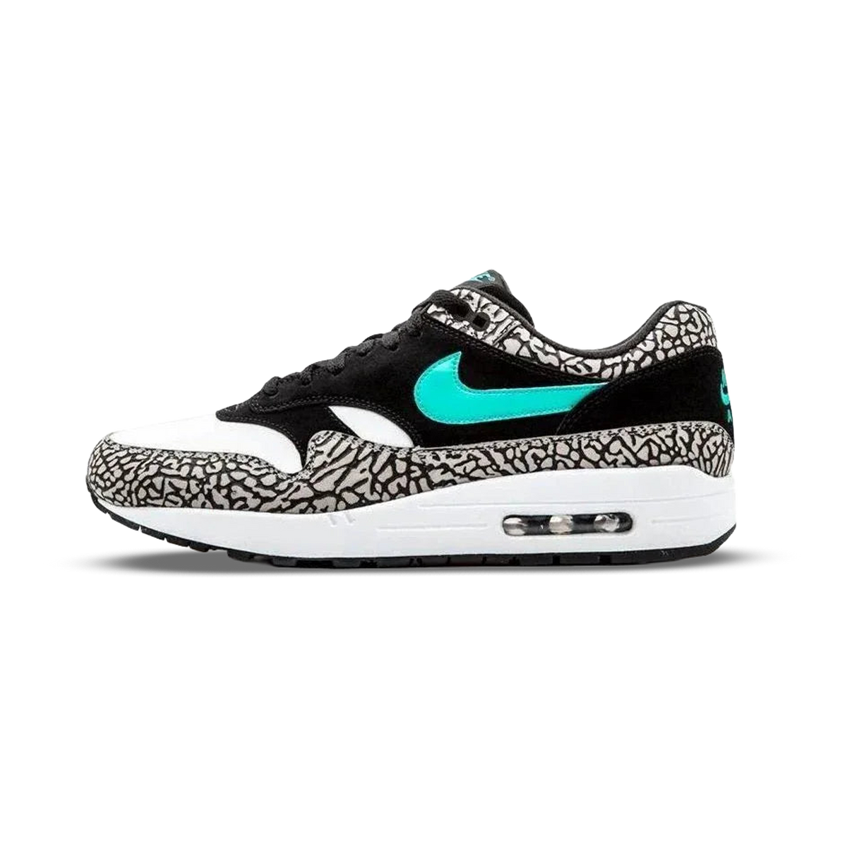 Widok z boku na buta Nike Air Max 1 w czarno, biało i szarym wzorze słonia, z turkusowym Swooshem i widoczną poduszką powietrzną w pięcie.