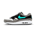 Widok z boku na buta Nike Air Max 1 w czarno, biało i szarym wzorze słonia, z turkusowym Swooshem i widoczną poduszką powietrzną w pięcie.
