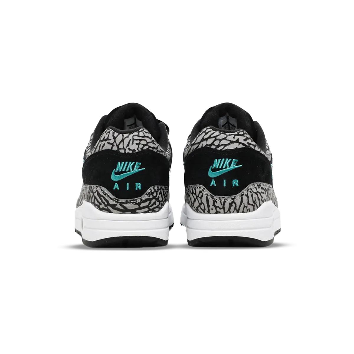 Widok z tyłu na parę sneakersów Nike Air Max 1 w czarno szarym wzorze słonia, z turkusowym haftem Nike Air na piętach i białymi podeszwami środkowymi.