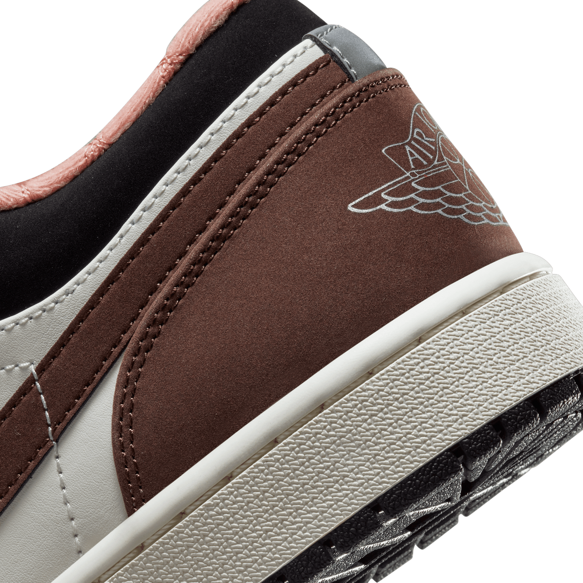 Close-up of the heel of a brown, white, and black Air Jordan 1 Low with a pink lining and the Wings logo printed on the heel panel.
