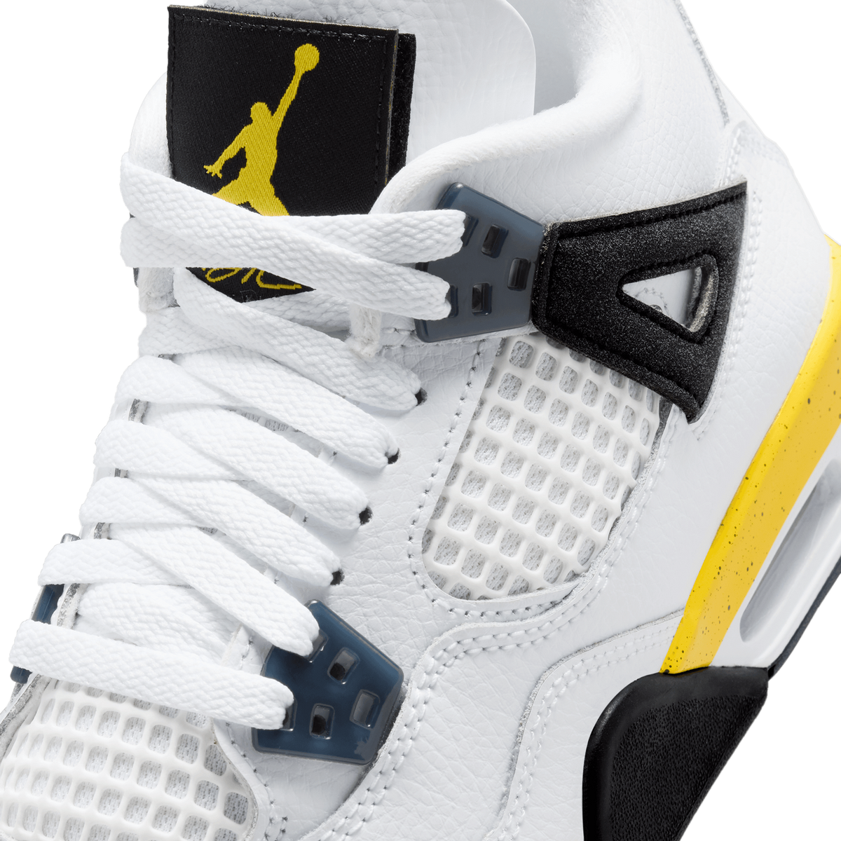 Close-up of a white Jordan 4 sneaker's tongue, eyelets, and lacing hardware with a black Jumpman tag and yellow accent on the side panel