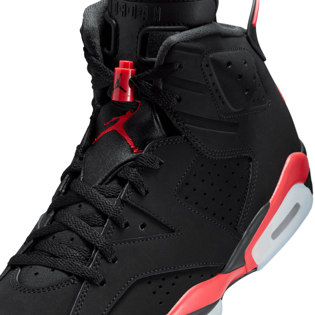 Close-up of a black Jordan 6 sneaker showing the red Jumpman lace lock, embroidered Jumpman logo on the tongue, and red infrared midsole detailing.