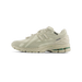 Lateral view of a cream New Balance 1906R Gore-Tex sneaker with tonal stitched overlays, an N logo on the side, and a green accent on the heel outsole.