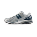 Side view of a New Balance 1906R running shoe in silver and white mesh with deep blue accents and an N-lock overlay, toe pointing left.