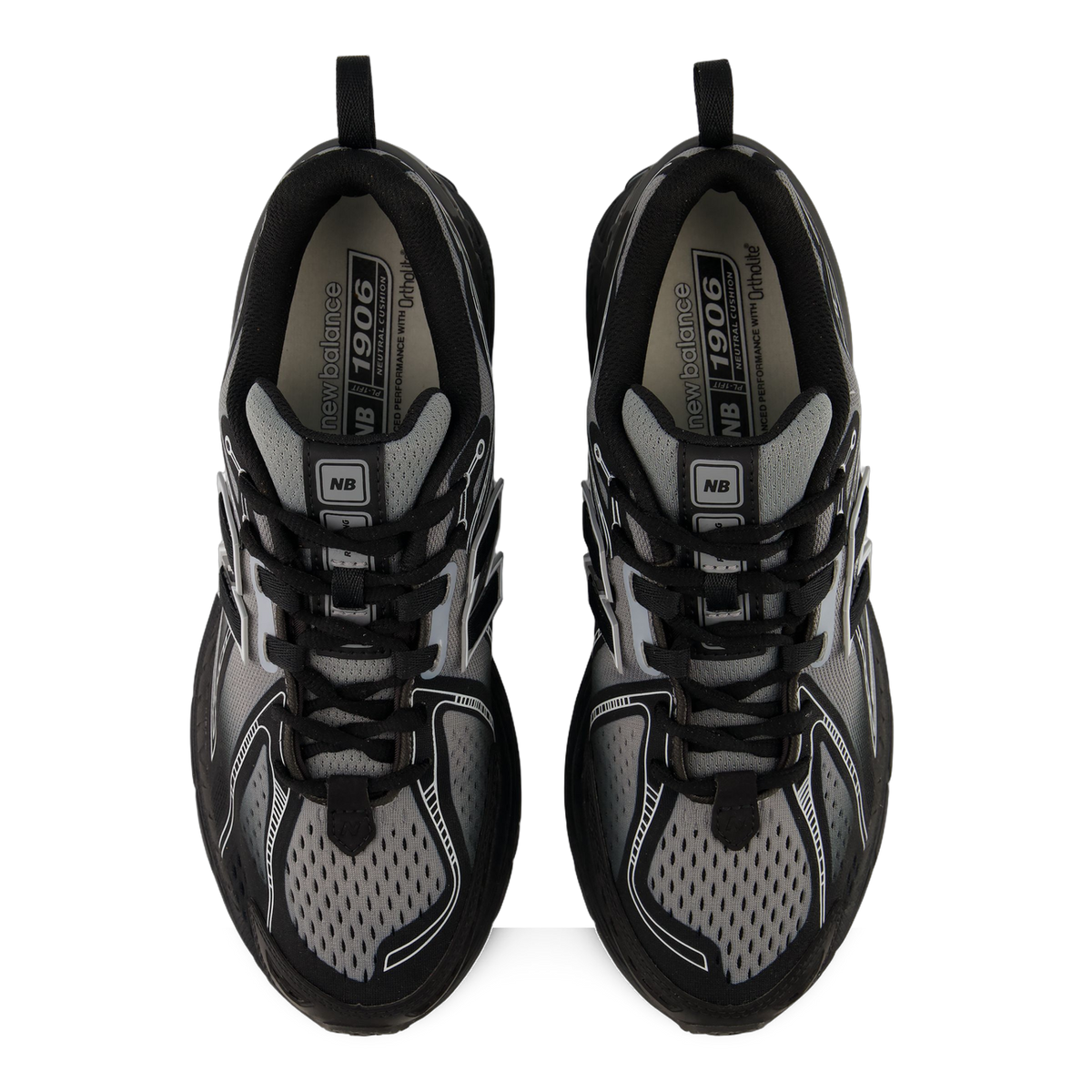 Top-down view of a pair of black and grey New Balance 1906 sneakers showing laced uppers and branded insoles with '1906 Neutral Cushion' text.