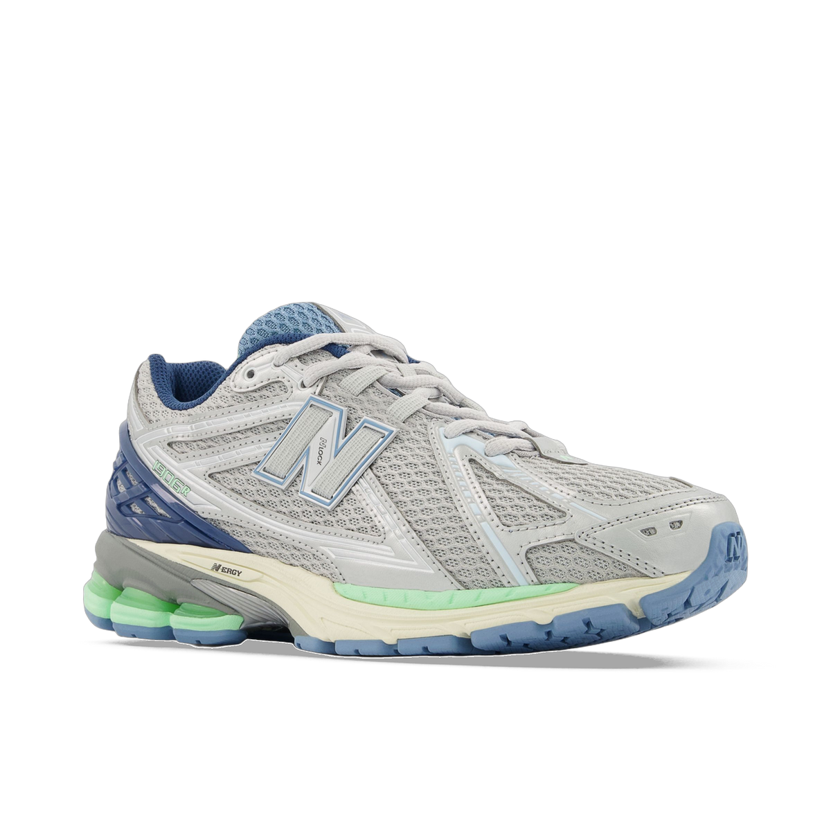 Angled side view of a gray New Balance 1906R sneaker with navy blue heel accents, light blue N logo, and green and cream midsole detailing.