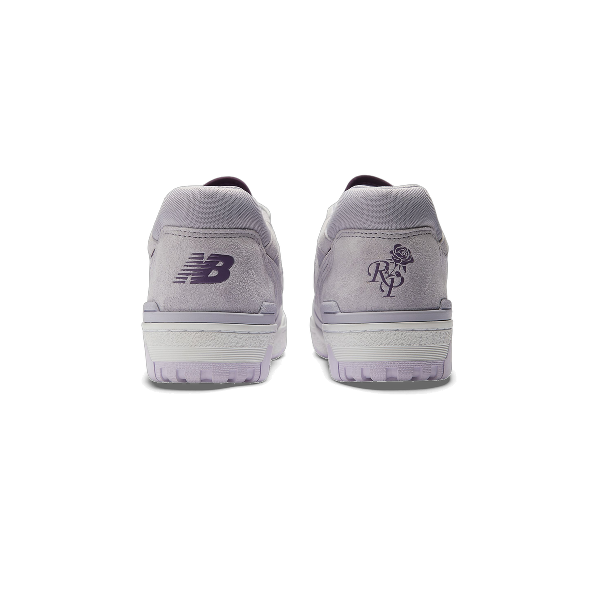 Rear view of a pair of lavender grey suede New Balance 550 sneakers with purple New Balance logo and a rose with RP monogram on the heels, white midsoles, and translucent purple outsoles.