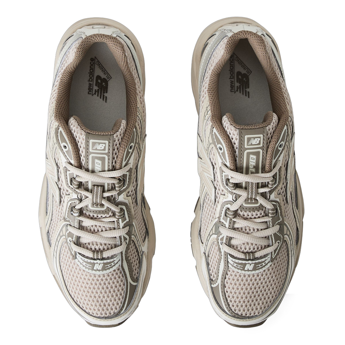 Top-down view of a pair of beige New Balance 740 sneakers with mesh uppers, tan overlays, and visible New Balance branding on the insoles and tongues.