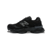 Side view of a black New Balance 9060 sneaker with suede and mesh panels, chunky midsole, and silver-outlined N logo