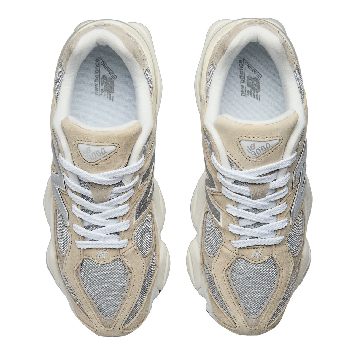 Top-down view of a pair of beige and gray New Balance 9060 sneakers with white laces, facing toward each other, showing the open collar and mesh toe panels.