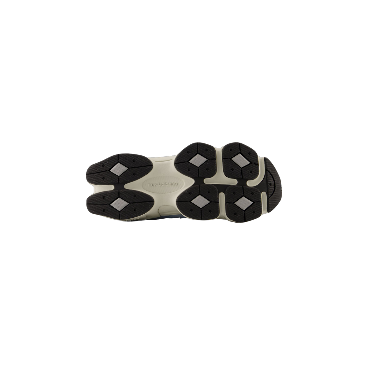 Bottom view of a New Balance 9060 sneaker showing the off-white outsole with black diamond-pattern tread and New Balance logo embossed in the center