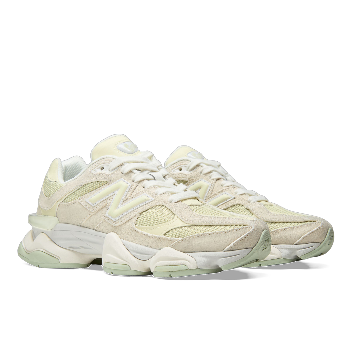 Pair of New Balance 9060 sneakers in cream and pale green with suede and mesh panels, angled toward the left showing the side N logo