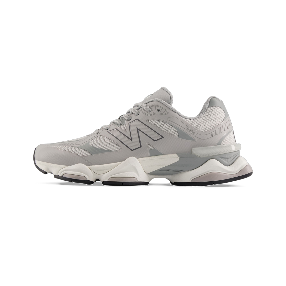 Lateral view of a gray New Balance 9060 sneaker with mesh panels, chunky white and gray midsole, and a black outsole.