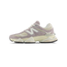 Side view of a New Balance 9060 sneaker in taupe and cream with a suede upper, white N logo, and cream chunky midsole, toe pointing left.