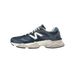 Side view of a navy blue New Balance 9060 sneaker with a white logo, toe pointing left, and a chunky off-white midsole