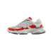 Side view of a white and red New Balance 9060 sneaker with toe pointing left, showing the white N logo and chunky grey midsole.