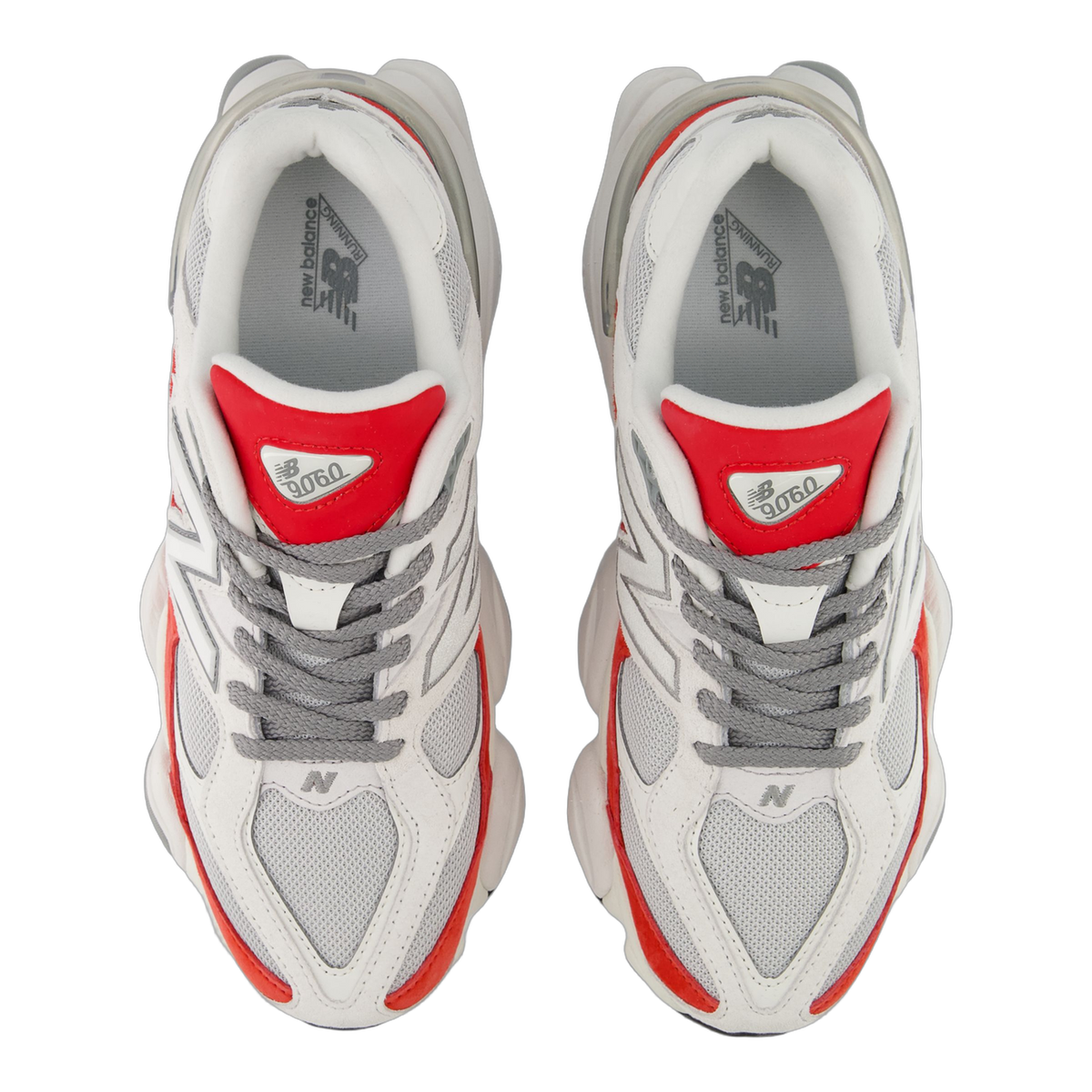 Top-down view of a pair of white New Balance 9060 sneakers with red heel tabs, grey laces, and silver N logos on the sides.